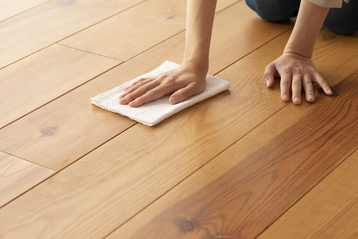 Ručné olejovanie drevenej podlahy bavlnenou handrou.